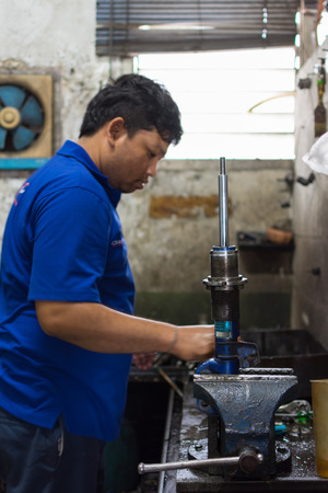 Bangkok, Thailand - May 28, 2016 : Unidentified serviceman checking shock absorber in car suspension at garageのeditorial素材