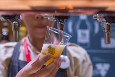 Bangkok, Thailand - May 28, 2016 : Unidentified barman or bartender pouring a draught lager beer from beer tap on counter for serving in a restaurant or pub.のeditorial素材
