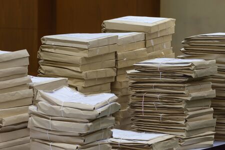 Old files in envelope paper stacking up in a messy order.