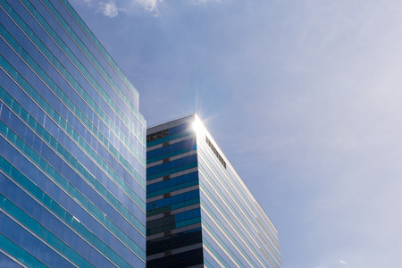 Big glass office building with blue sky and white cloud