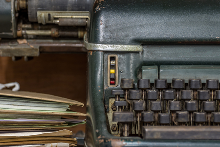 Typewriter antique vintage style with old documents or old letter for writer on wooden desk zoom in front view of typewriter, writer or editor in vintage office concept.の写真素材