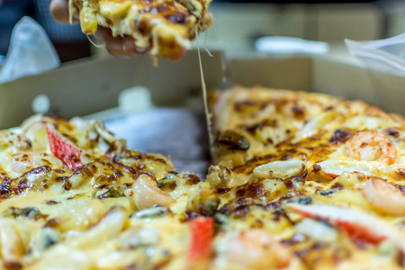 Pizza is a italian food served on wooden circle boardの写真素材