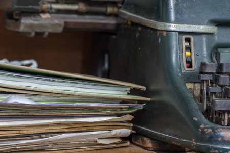 Typewriter antique vintage style with old documents or old letter for writer on wooden desk zoom in front view of typewriter, writer or editor in vintage office concept.の写真素材