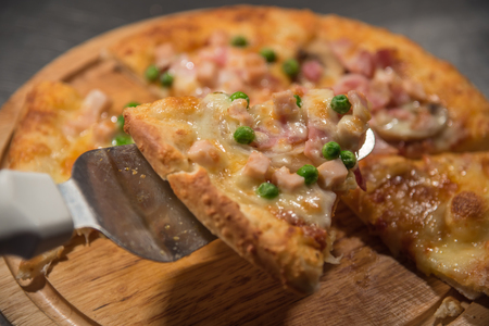 Pizza is a italian food served on wooden circle boardの写真素材