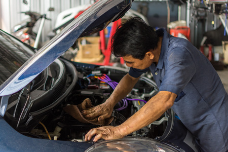 Bangkok, Thailand - March 9, 2017 : Unidentified car mechanic or serviceman checking a car engine for fix and repair problem at car garage or repair shopのeditorial素材