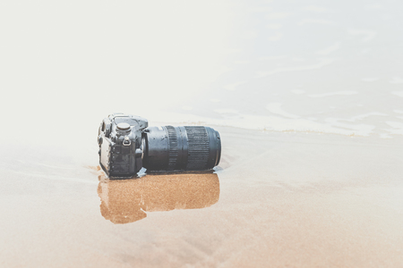 Photographer demo waterproof for DSLR camera and tele lens by wet from water sea wave at beach when travel and test using in the extreme environmentの写真素材