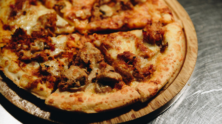 Pizza is a italian food served on wooden circle boardの写真素材