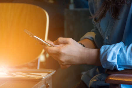 Mobile phone and women on wood table in coffee shop or restaurantの写真素材
