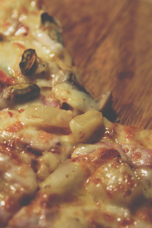 Pizza is a italian food served on wooden circle boardの写真素材
