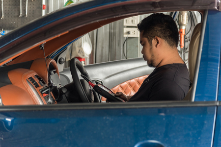 Bangkok, Thailand - May 5, 2017 : Unidentified car mechanic or serviceman checking a car engine by OBD-II electric tools for fix and repair problem at car garage or repair shopのeditorial素材