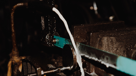 Hack sawing machine working to cutting a metal or iron casting with water in manufacturingの写真素材