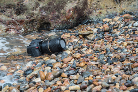 Rayong, Thailand - May 28, 2017 : Unidentified photographer demo waterproof for DSLR camera and tele lens by wet from water sea wave at beach when travel and test using in the extreme environmentのeditorial素材