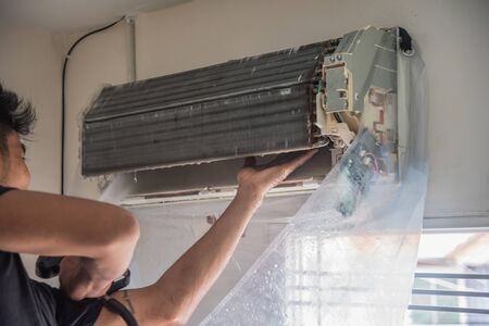 Bangkok, Thailand - July 22, 2017 : Unidentified worker to cleaning coil cooler of air conditioner by water for clean a dust on the wall in customer home when maintenance serviceのeditorial素材