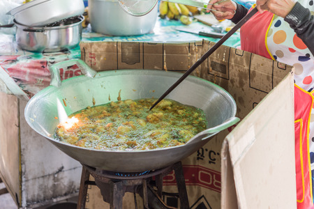 Bangkok, Thailand - July 23, 2017 : Unidentified chef cooking a Thai dessert desame balls (Kanom Kai Hong) for sale at Thai street food marketのeditorial素材