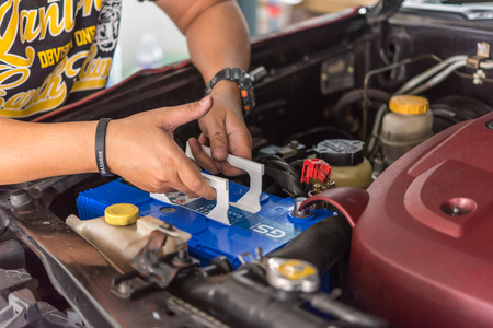 Bangkok, Thailand - August 5, 2017 : Unidentified car mechanic or serviceman checking a car battery for fix and repair problem at car garage or repair shopのeditorial素材