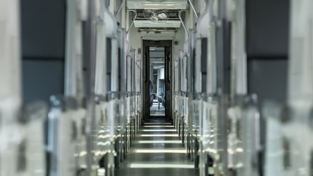 Inside of old public Thai railway train cabin with seats, handrails, fan and interior in vintage style service for passenger transportの写真素材