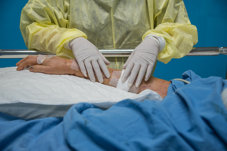 Asian women 40s years old is a patient relative taking care of the CRE. or VRE. infected elder patient 80s years old on bed in the hospital.のeditorial素材