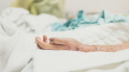 Patient in the hospital with incontinent pad and elderly patient handの写真素材