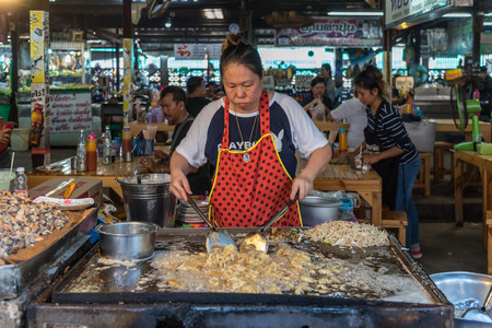 Chachoengsao, Thailand - October 15, 2017 : Unidentified chef cooking a Fried mussel pancakes or Mussel fried in egg batter (Hoi Tod) for sale at Thai street food marketのeditorial素材