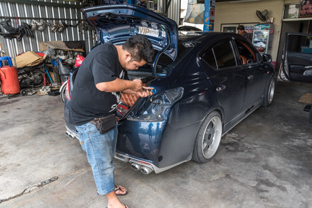 Bangkok, Thailand - June 10, 2017 : Unidentified car mechanic or serviceman checking a car taillight for fix and repair problem with brake light for security at car garage or repair shopのeditorial素材