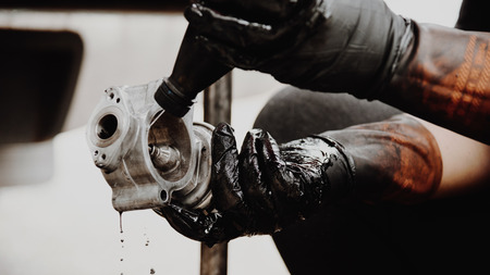 Car mechanic or serviceman disassembled car dirty engine for cleaning fuel injection and air flow system engine parts for fix and repair problem at car garage or repair shopの写真素材