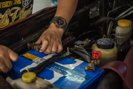 Bangkok, Thailand - August 5, 2017 : Unidentified car mechanic or serviceman checking a car battery for fix and repair problem at car garage or repair shopのeditorial素材