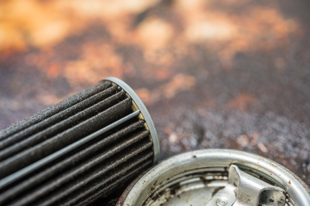 Old lubricant engine oil filter at car garage after changing the new oil filter for repair or maintenance in a car engineの写真素材