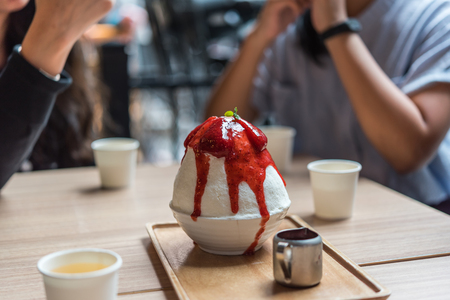 Bingsu or Bingsoo (Patbingsu) is a popular Korean shaved ice dessert with sweet toppings that may include chopped fruit, condensed milk, fruit syrup, and varieties with ingredientsの写真素材