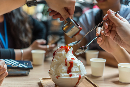 Bingsu or Bingsoo (Patbingsu) is a popular Korean shaved ice dessert with sweet toppings that may include chopped fruit, condensed milk, fruit syrup, and varieties with ingredientsの写真素材