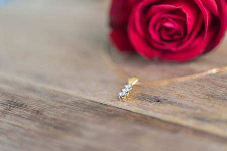 Red rose flower nature beautiful flowers from garden and diamond necklace ring for valentines or marriage on wooden floor with copy space in Valentine's Day, Wedding or Romantic Love Valentine conceptの写真素材