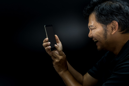 Asian man using smartphone on black backgroundの写真素材