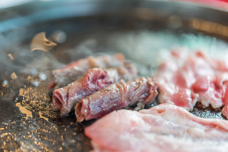 Grilled raw meat beef and pork (barbeque, bbq) a food cooking on wagyu grill in BBQ. yakiniku grill buffet restaurantの写真素材