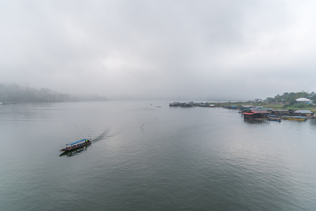 Landscape of river and raft or houseboat with morning mist and coolness from predawn fog is a nature travel in Sangkhla buri Kanchanaburi, Thailandの写真素材