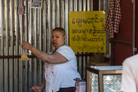Payathonzu, Myanmar - March 2, 2018 : Mon woman sale flower at Golden Pagoda at Tai Ta Ya Monastery or Wat Sao Roi Ton Temple, Buddhist temple at Payathonsu in the south of Kayin State, Myanmarのeditorial素材