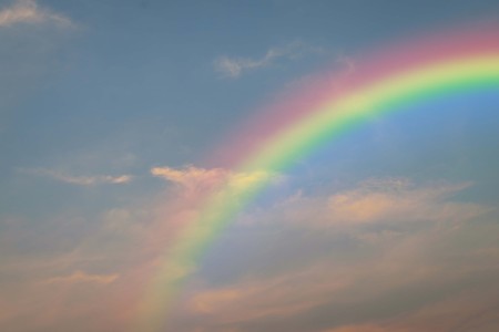 Cloudscape rainbow of natural sky with red sky and white clouds and colorful rainbow in the sky use for wallpaper backgroundの写真素材