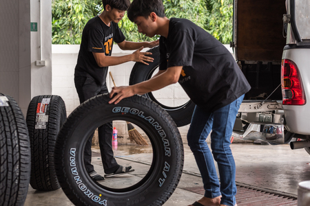 Bangkok, Thailand - August 31, 2017 : Unidentified car mechanic or serviceman disassembly and checking a car alloy chrome wheel for fix and repair suspension problem at car garage or repair shopのeditorial素材
