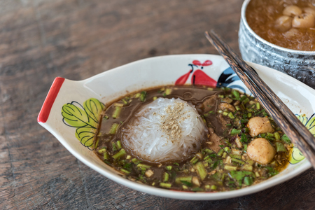 Braised beef clear noodle with meat balls soup stew (Ekaehla meat) with vegetable in bowl for sale at Thai street food market or restaurant in Thailandの写真素材