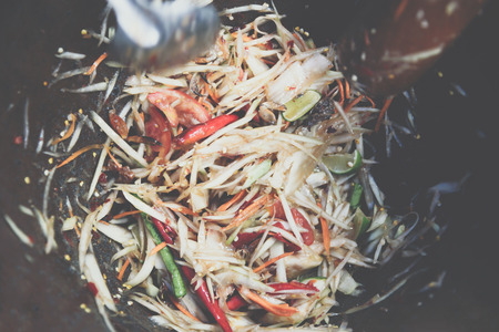Papaya salad or Papaya Pok Pok (Som tum) for sale at Thai street food market or restaurant in...