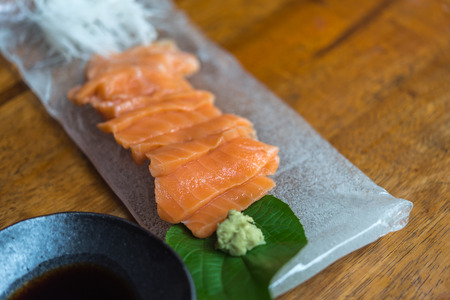 Japanese food delicacy consisting sashimi salmon of very fresh raw salmon fish sliced into thin pieces serving with radish sliced in japanese restaurantの写真素材