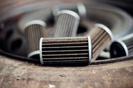 Old lubricant engine oil filter at car garage after changing the new oil filter for repair or maintenance in a car engineの写真素材