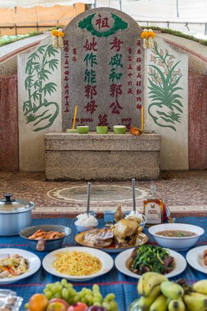 Prachinburi, Thailand - April 7, 2019 : Thai Chinese respect ancestors parents those died by food and burn fake money to sacrifice them at cemetery in Qingming Festival (Qing Ming), Tomb-Sweeping Dayのeditorial素材