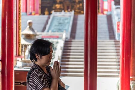 Thai buddhism people in buddhist pray for benefaction worship to Buddha at Chinese temple under the patronage of the Chinese Buddhist Sangha in Thailand or Mahayana Buddhismの写真素材