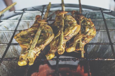 Grilled chicken sauce is a Thai barbeque food by chicken and sauce cooking on charcoal with flames at Thai street food marketの写真素材