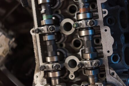 Disassembled car dirty engine close-up to engine parts and cylinder head at car garage