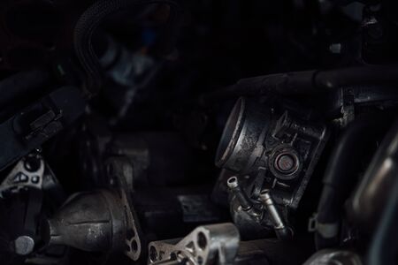 Disassembled car dirty engine close-up to engine parts and cylinder head at car garageの写真素材