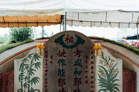 Prachinburi, Thailand - April 7, 2019 : Thai Chinese respect ancestors parents those died by food and burn fake money to sacrifice them at cemetery in Qingming Festival (Qing Ming), Tomb-Sweeping Dayのeditorial素材