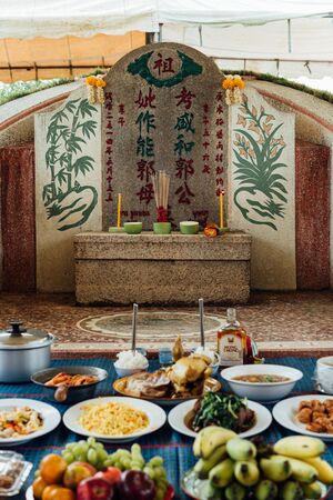 Prachinburi, Thailand - April 7, 2019 : Thai Chinese respect ancestors parents those died by food and burn fake money to sacrifice them at cemetery in Qingming Festival (Qing Ming), Tomb-Sweeping Dayのeditorial素材