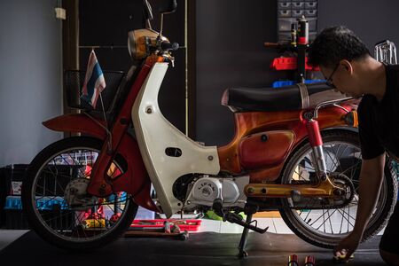 Bangkok, Thailand - March 30, 2019 : Unidentified mechanic or serviceman checking a classic retro motorcycle (Japan motorcycle vintage style) for fix and repair problem at garage or repair shopのeditorial素材