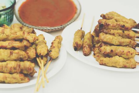 Pork satay with peanut sauce served with pickles which are cucumber slices and onions in vinegar at Thai street food market or restaurant in Bangkok Thailandの写真素材