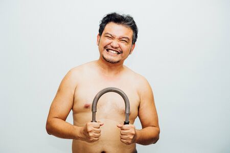 Asian man 40s fat body from obesity and diabetes tired effort exercise by use Arm Chest Strength...